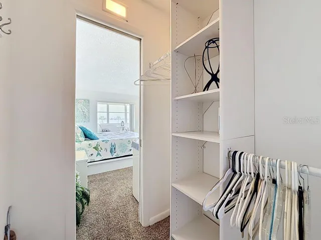 Organized walk-in closet featuring built-in shelving and plenty of hanging space
