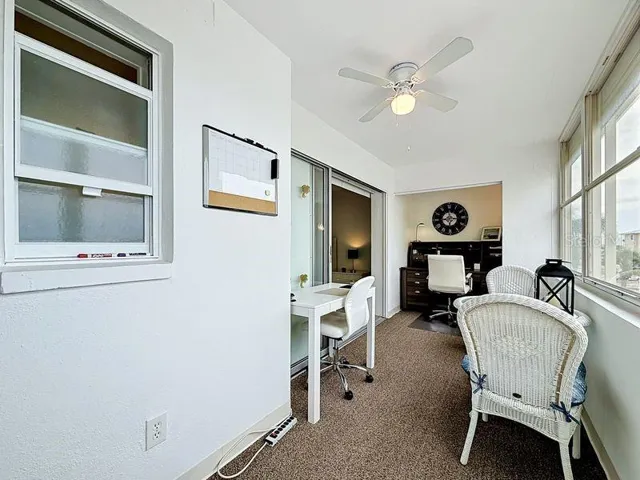 Versatile Florida Room with bright natural light, beautiful intercoastal views, and sliding glass doors- perfect for relaxing or working from home.