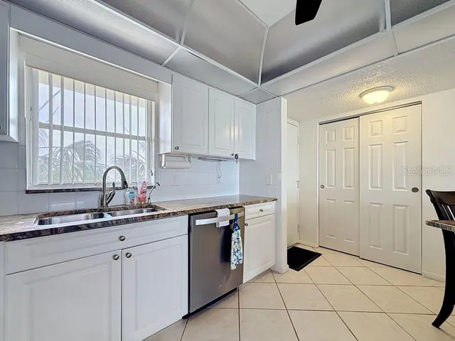 Modern coastal charm kitchen with tile floors, sleek finishes, and a layout that flows endlessly for entertaining.