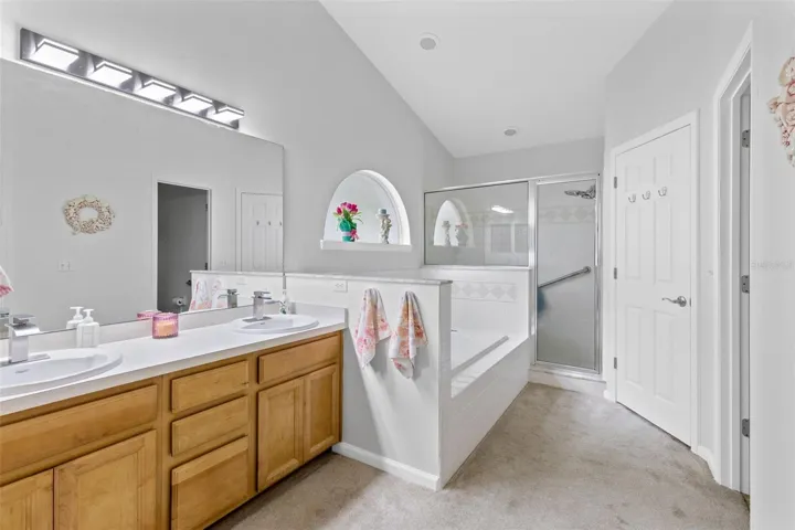 Primary bath with double vanities, tub, shower and large walk-in closet