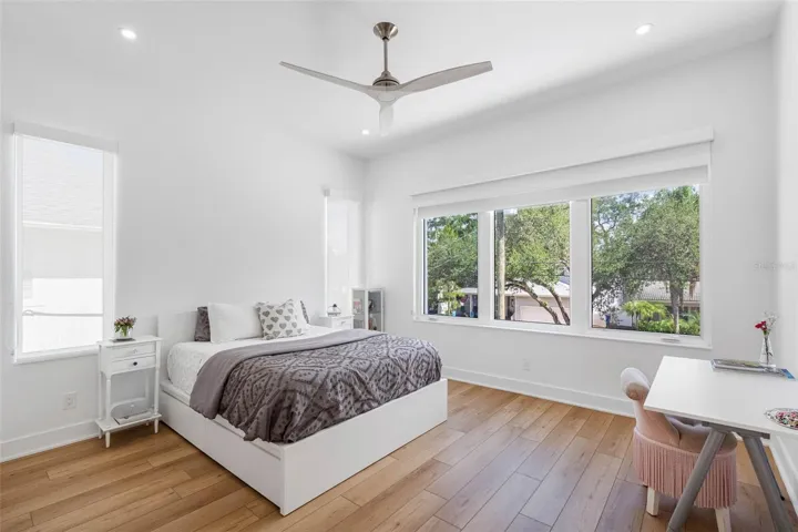 Bedroom 2 boats en-suite bath with glass-enclosed shower, closest system, window treatment, dimmable lights, and Minka ceiling fan, known for their quiet operation and distinctive style