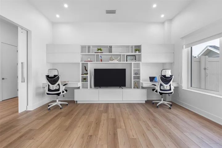Office space features built-ins with multiple drawers, black outs and shades