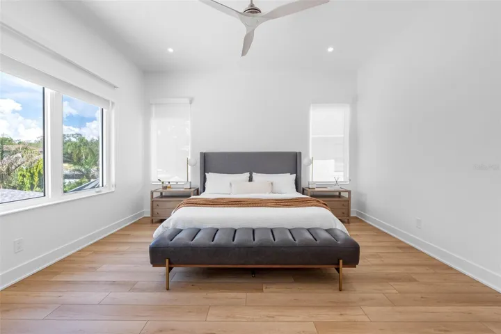 French doors open to the ample master bedroom featuring his and her walking closet with built-ins, dimmable lights, window treatment and Minka ceiling fan, known for their quiet operation and distinctive style