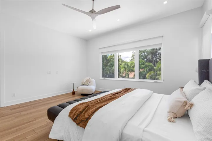 nch doors open to the ample master bedroom featuring his and her walking closet with built-ins, dimmable lights, window treatment and Minka ceiling fan, known for their quiet operation and distinctive style