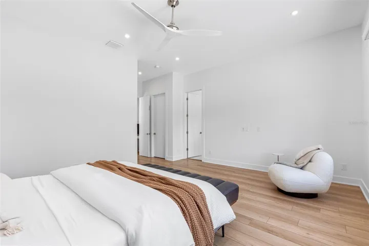 nch doors open to the ample master bedroom featuring his and her walking closet with built-ins, dimmable lights, window treatment and Minka ceiling fan, known for their quiet operation and distinctive style