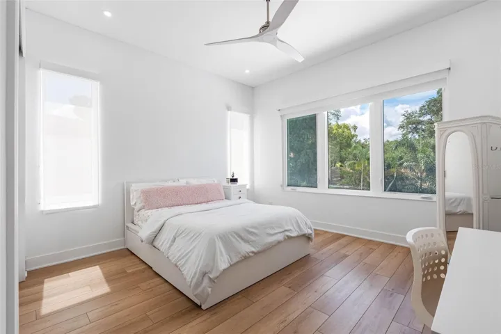 Bedroom 4 boats en-suite bath with glass-enclosed shower, closest system, window treatment, dimmable lights, and Minka ceiling fan, known for their quiet operation and distinctive style
