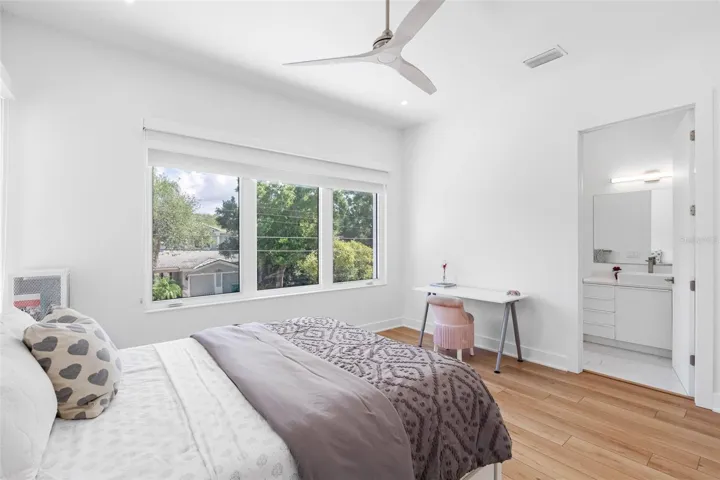 Bedroom 2 boats en-suite bath with glass-enclosed shower, closet system, window treatment, dimmable lights, and Minka ceiling fan, known for their quiet operation and distinctive style
