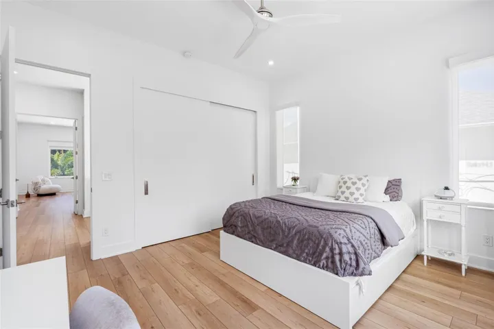 Bedroom 2 boats en-suite bath with glass-enclosed shower, closest system, window treatment, dimmable lights, and Minka ceiling fan, known for their quiet operation and distinctive style