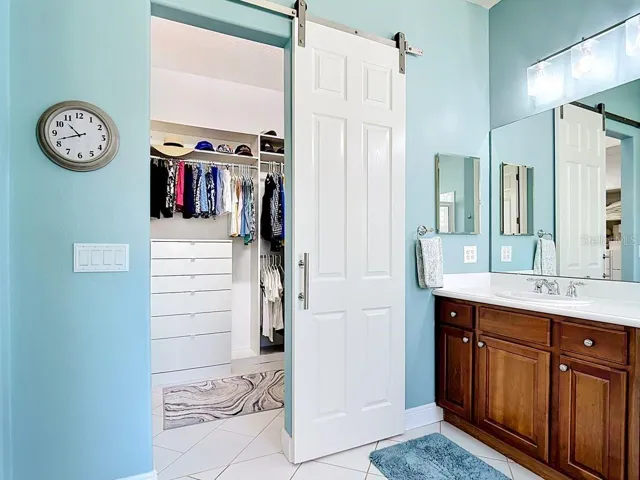 Large custom closet with tile flooring and barn door entry