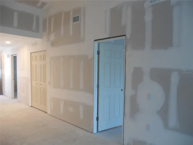 VIEW OF THE LIVING ROOM. DOOR ON THE RIGHT LEADS TO PRIMARY BEDROOM. DOUBLE DOORS ARE TO THE STORAGE CLOSET.