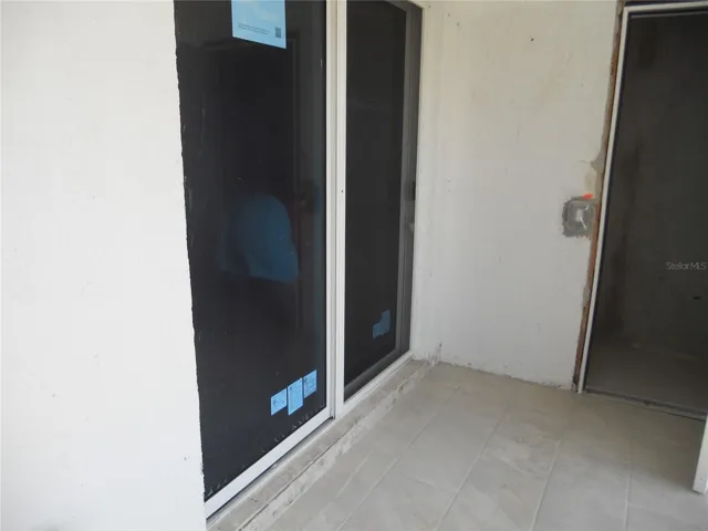 HURRICANE RATED SLIDING DOOR LEADS TO THE PRIMARY BEDROOM FROM THE BALCONY.