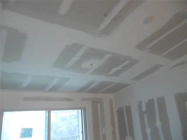 PRIMARY BEDROOM. SLIDING DOOR TO BALCONY. SPRINKLER SYSTEM HAS BEEN INSTALLED IN CEILINGS.