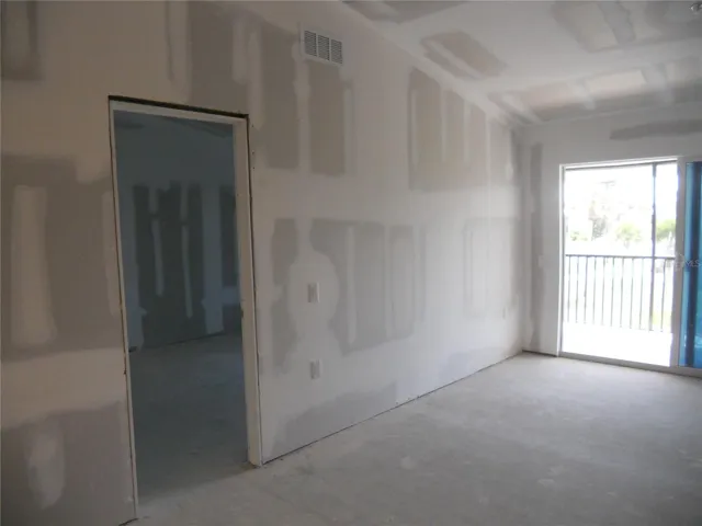 LIVING ROOM TO PRIMARY BEDROOM. SLIDING DOOR TO THE SCREENED BALCONY.