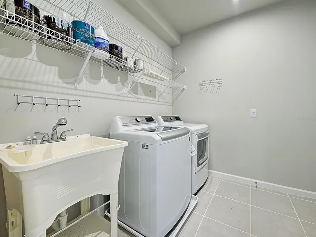Laundry room has utility sink and almost new, LG washer and dryer.