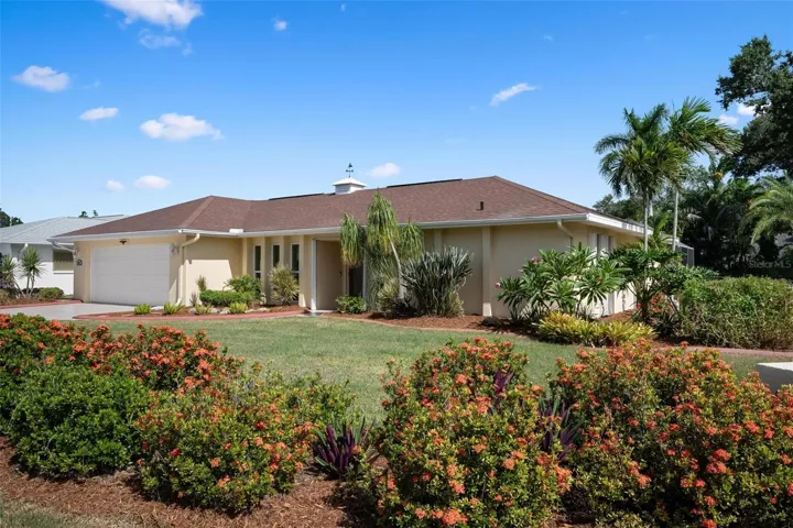 Front Elevation - Lush landscaping, mix of impact resistant windows and accordion hurricane shutters