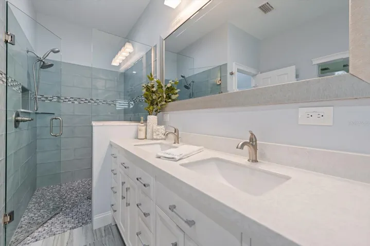 Spa like primary bath with walk in shower and attractive finishings