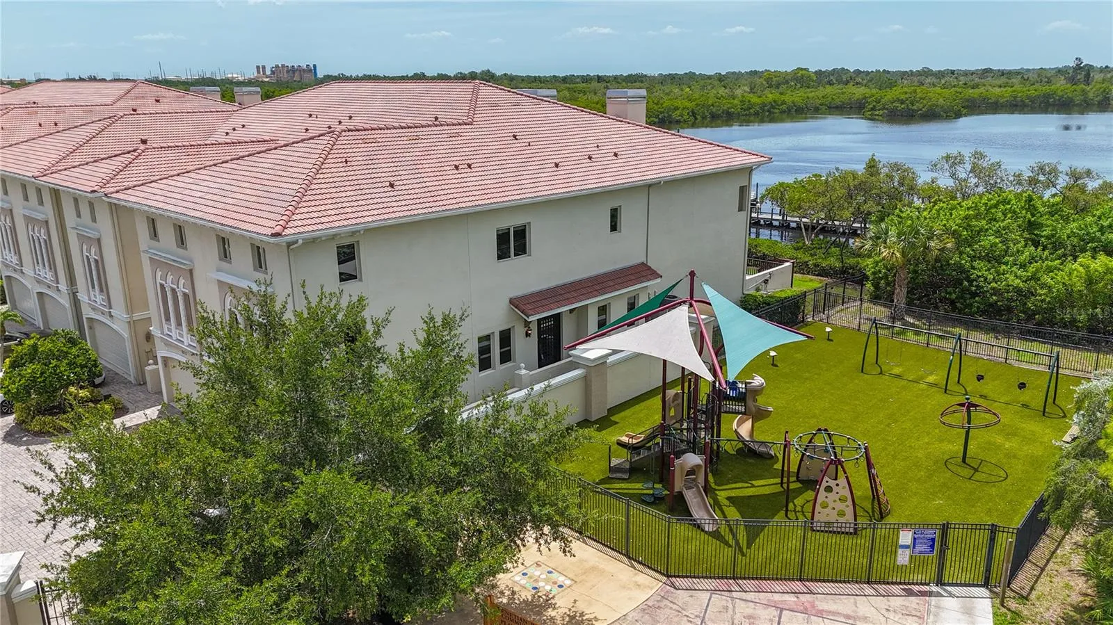 Sideyard showing the playground next to this end unit, and the waters of Weedon Island Preserve in the background.