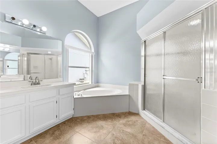 Primary bathroom has a separate garden tub and step in shower