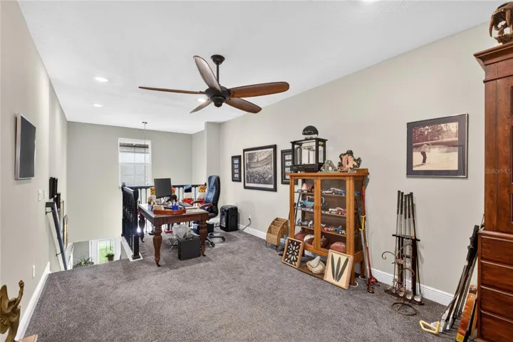 This photo features the staircase leading to the upper level, which is fully carpeted and includes a designated entertaining area.