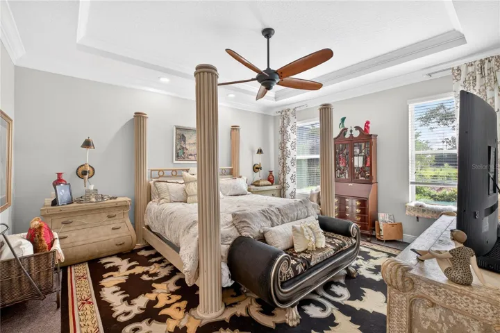 owners-suite with carpet and high ceilings featuring crown molding