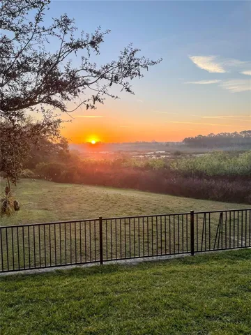 sunset view from backyard featuring conservation view.