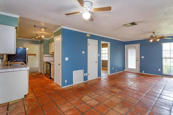 View from dining area in to living space and kitchen. Primary bedroom entrance visible in this photo