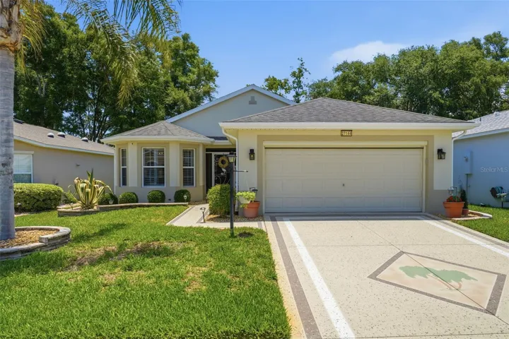 Impressive curb appeal highlighted by a painted driveway, lush landscaping, and a convenient electric garage screen, creating a welcoming first impression.