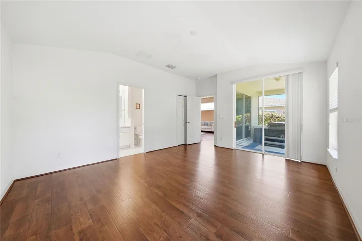 Spacious primary suite with walk-in closet, updated ensuite bath with remodeled shower, and sliding glass doors leading to your private spa retreat.