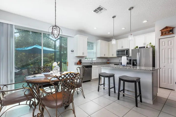 Bright open kitchen with natural light overlooks screened porch and greenery