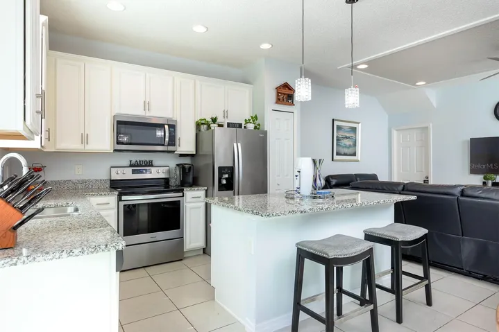 Kitchen island features granite breakfast bar
