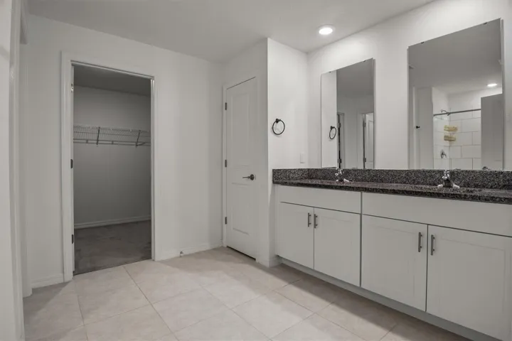 Ensuite bathroom with dual sinks, granite and large walk-in closet