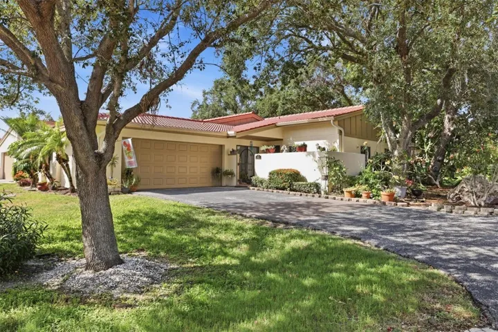Front elevation, framed by oaks