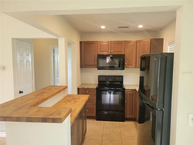 The kitchen offers newer wood cabinets, granite and butcher block countertops, and newer appliances.