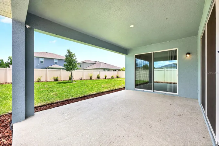 Covered overlooks a fully fenced backyard.