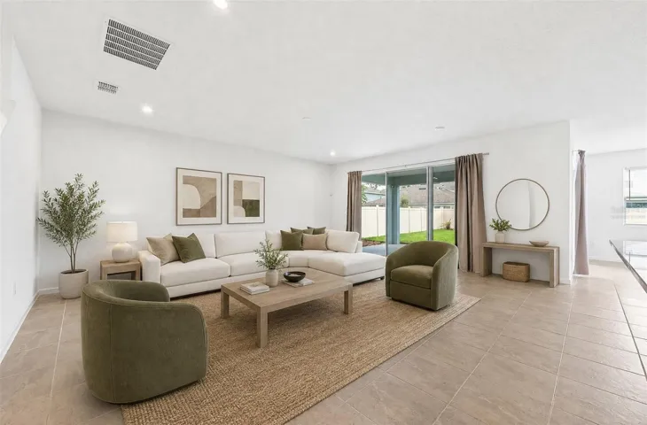 Open living area features triple sliding glass doors that open to the lanai. Virtually Staged.