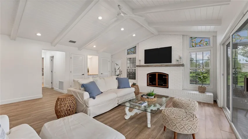 Living room with vaulted celings and gas fireplace with water views