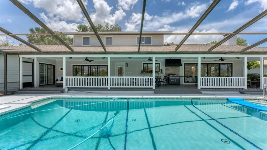 View of pool and covered porch under screen