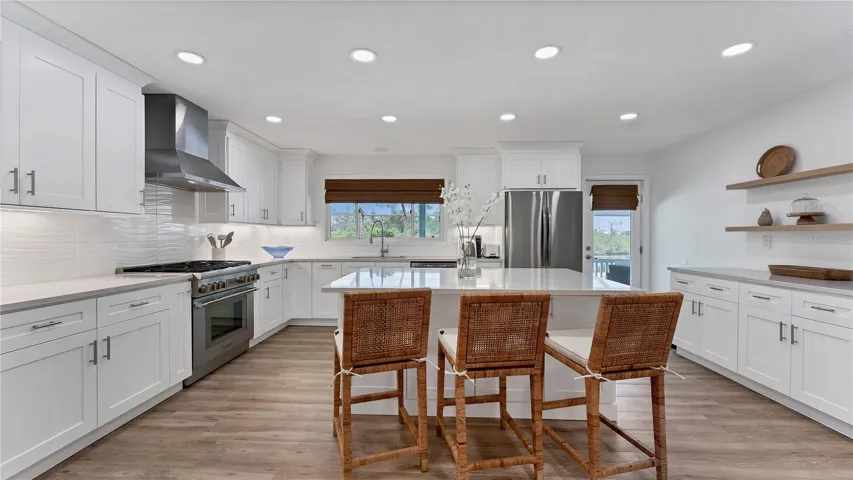 Gourmet kitchen with island and gas range with hood