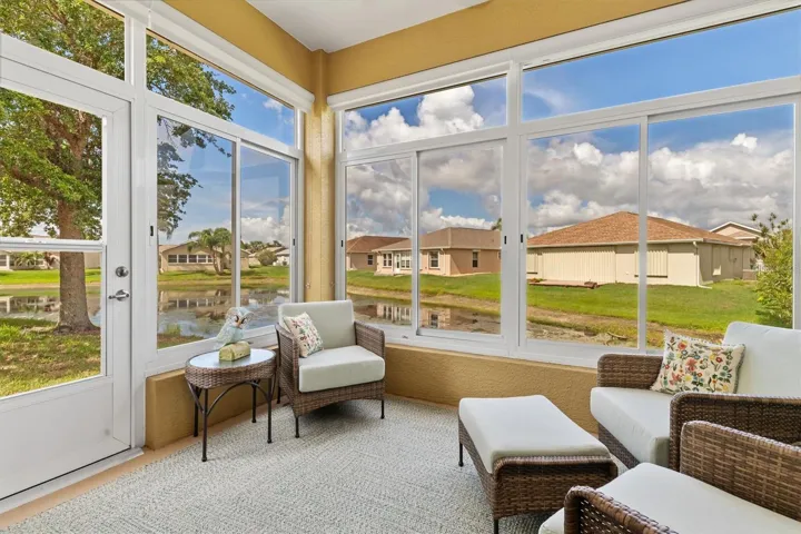 Enclosed sunroom with sliding windows and screens.  Lovely place to sit and enjoy cooler days. Tile floors and area rug.