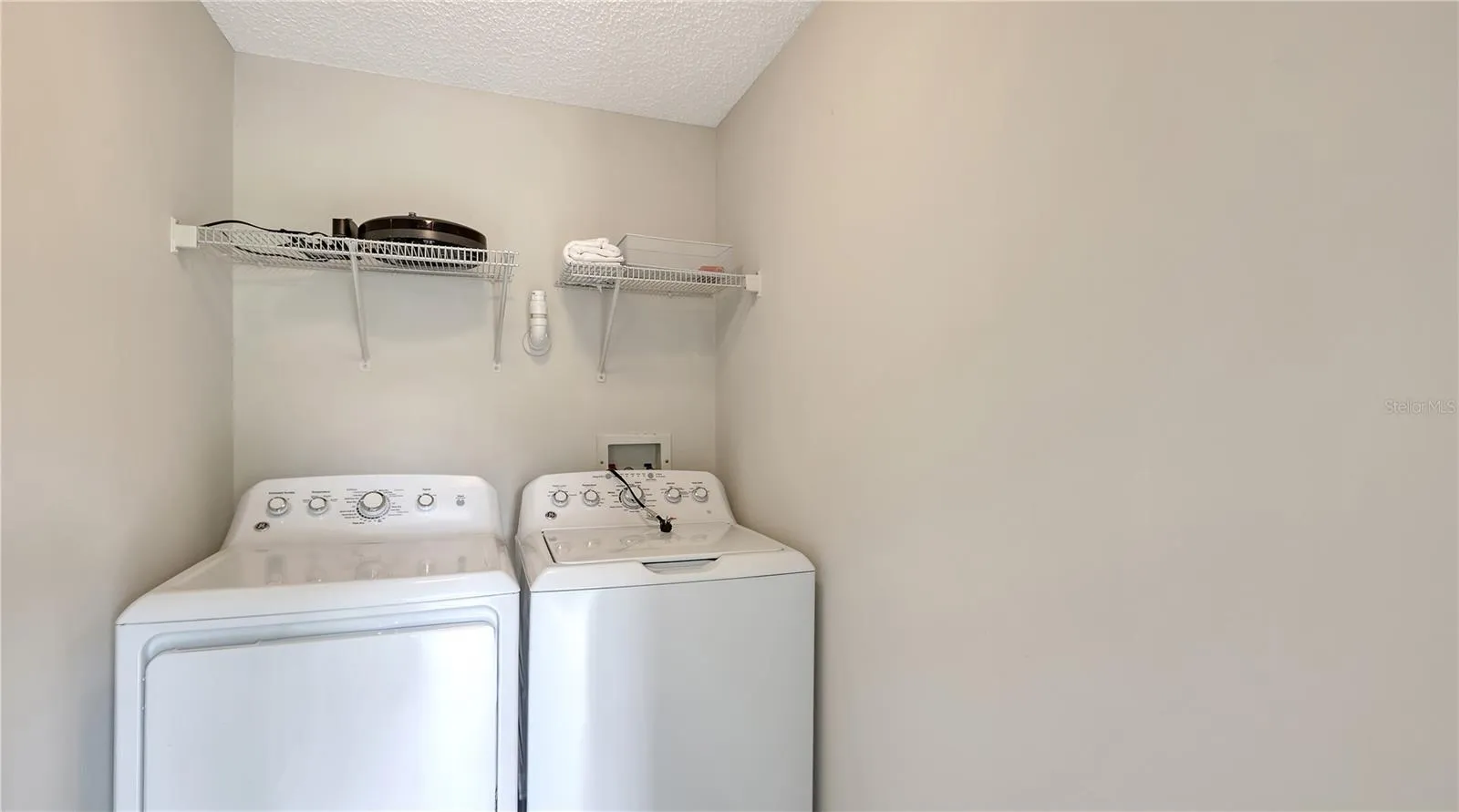 Laundry room with full-size laundry machine and a dryer.