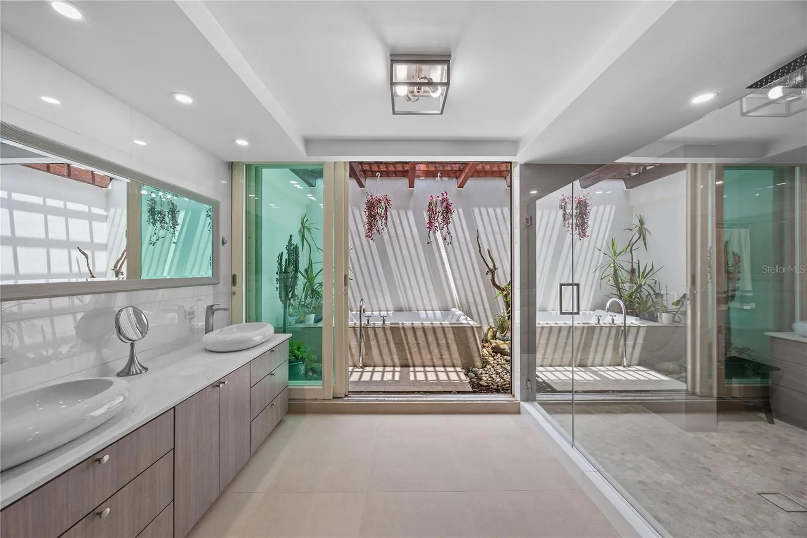 The recently remodeled spa-inspired bathroom includes dual vanities, an oversized walk-in shower, and a beautiful clawfoot soaking tub designed for relaxation outside.