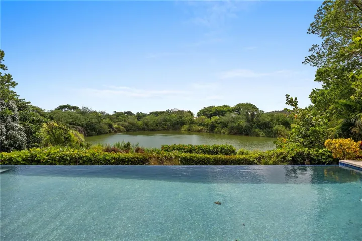 Nestled within the highly sought-after gated community of Sabanera Dorado, this exceptional Carbia model sits on one of the neighborhood's most desirable lots, offering a rare combination of privacy, lake views, generous outdoor space, and thoughtfully upgraded interiors.