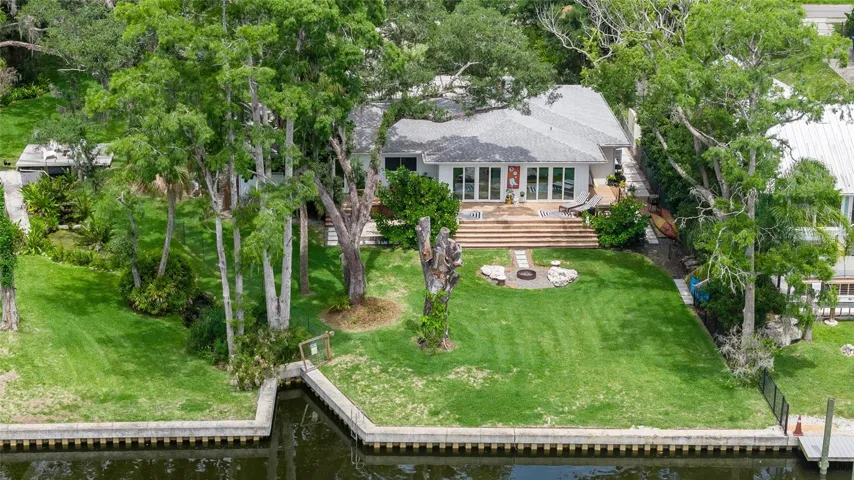 140 feet of engineered sea wall, .65 of an acre of picturesque lawns, a manicured spring, multiple fruit trees and palm trees
