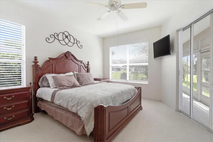 Master Bedroom w/ Slider to the Enclosed Sunroom, Dual Closets, a Convenient 3rd Closet & Ensuite w/ Dual Sinks, Water Closet & Tiled Shower