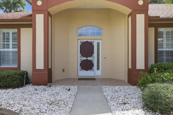 Covered Entry w/ Tiled Floor & Decorative Storm Door