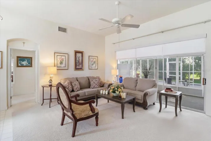 Living Room Features 3 Panel Stacking Slider w/ Electric Retractable Blind that Opens to the Enclosed Sunroom & Screened Lanai