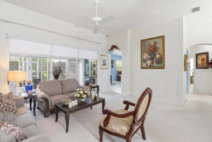 Living Room Features 3 Panel Stacking Slider w/ Electric Retractable Blinds that Opens to the Enclosed Sunroom & Screened Lanai