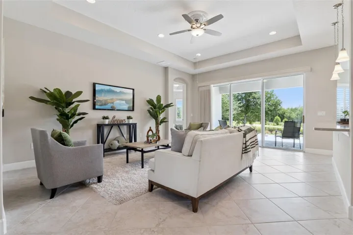 12'6" x 20' Great Room w/ tray ceiling, recessed lighting, electric floor outlet & a ceiling fan