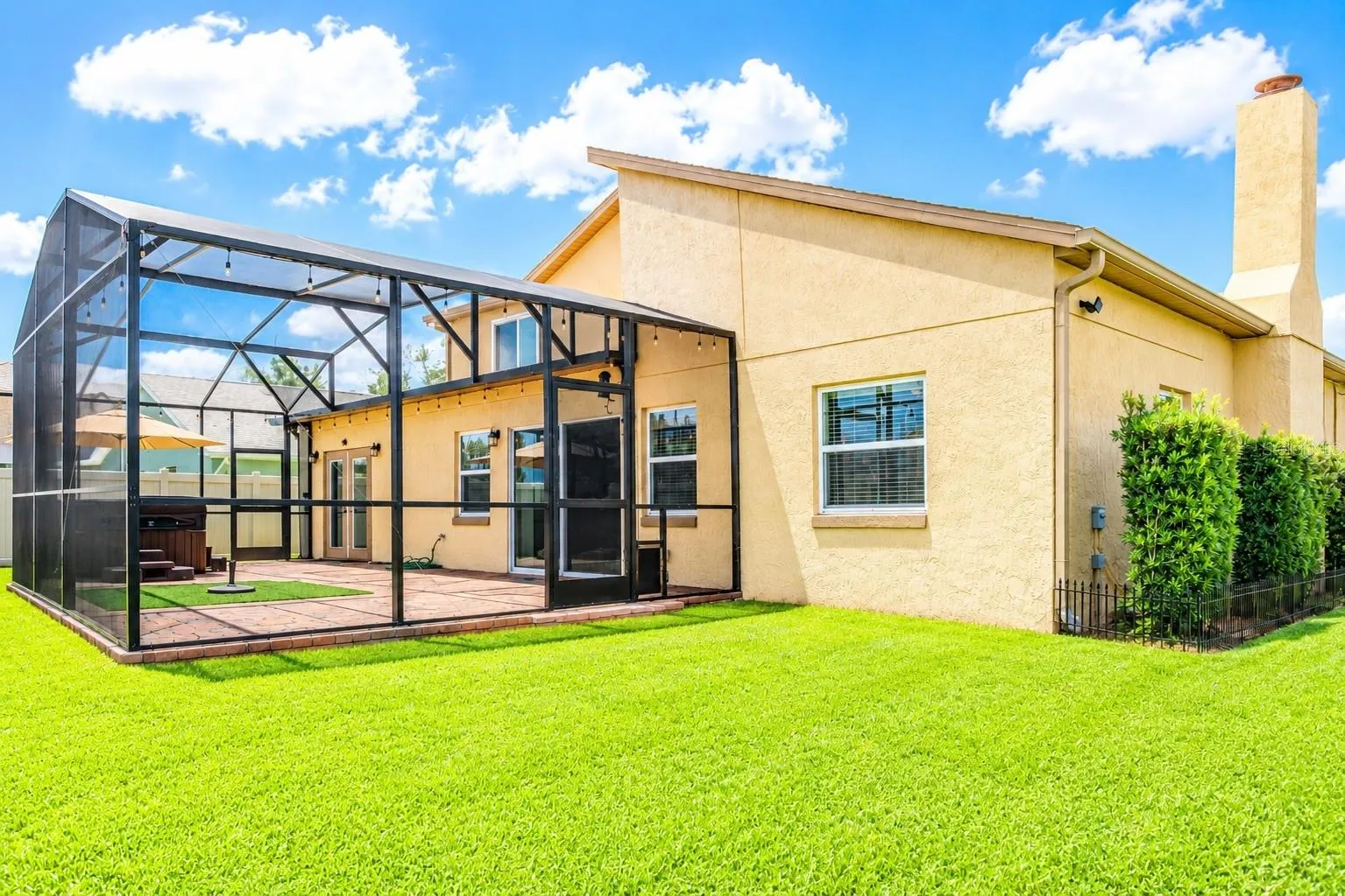 Pristinely Maintained Landscape Highlighting the Massive Architectural Structural Remodel, Showcasing the Screened in Lanai and Hot Tub.