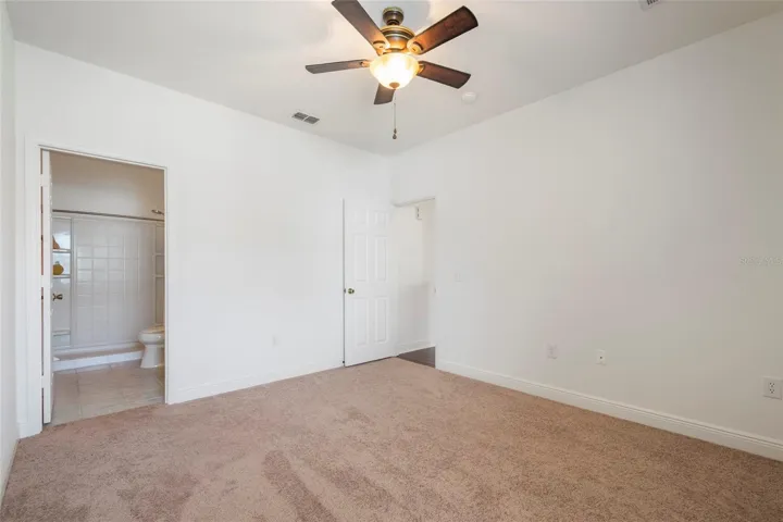 Primary Bedroom with en suite bathroom and ceiling fan.